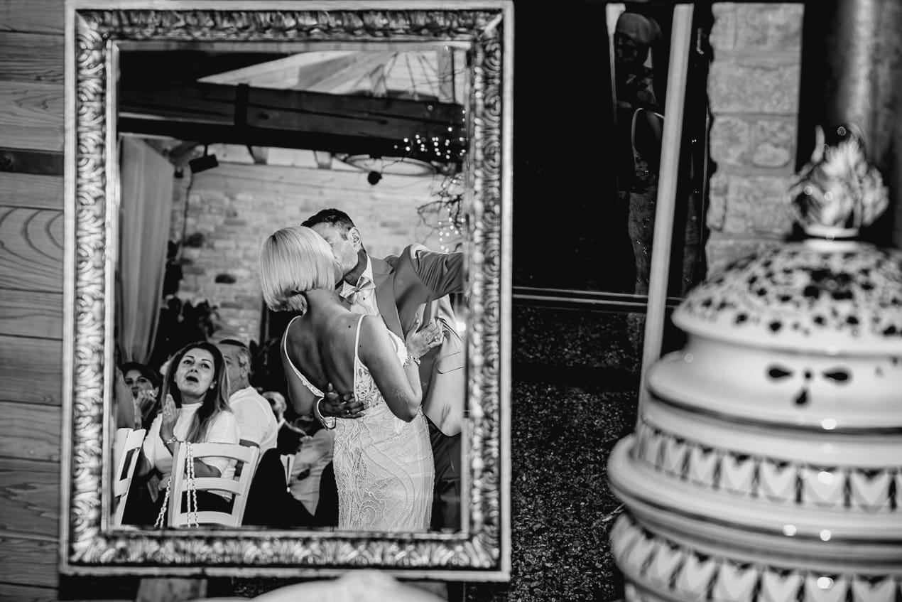 Matrimonio boho-chic da favola nel Monferrato. Fotografo matrimonio Monferrato. Matrimonio a Molare. Agriturismo "A Modo Mio" Ricevimento. Sposi si baciano. Riflessi nello specchio