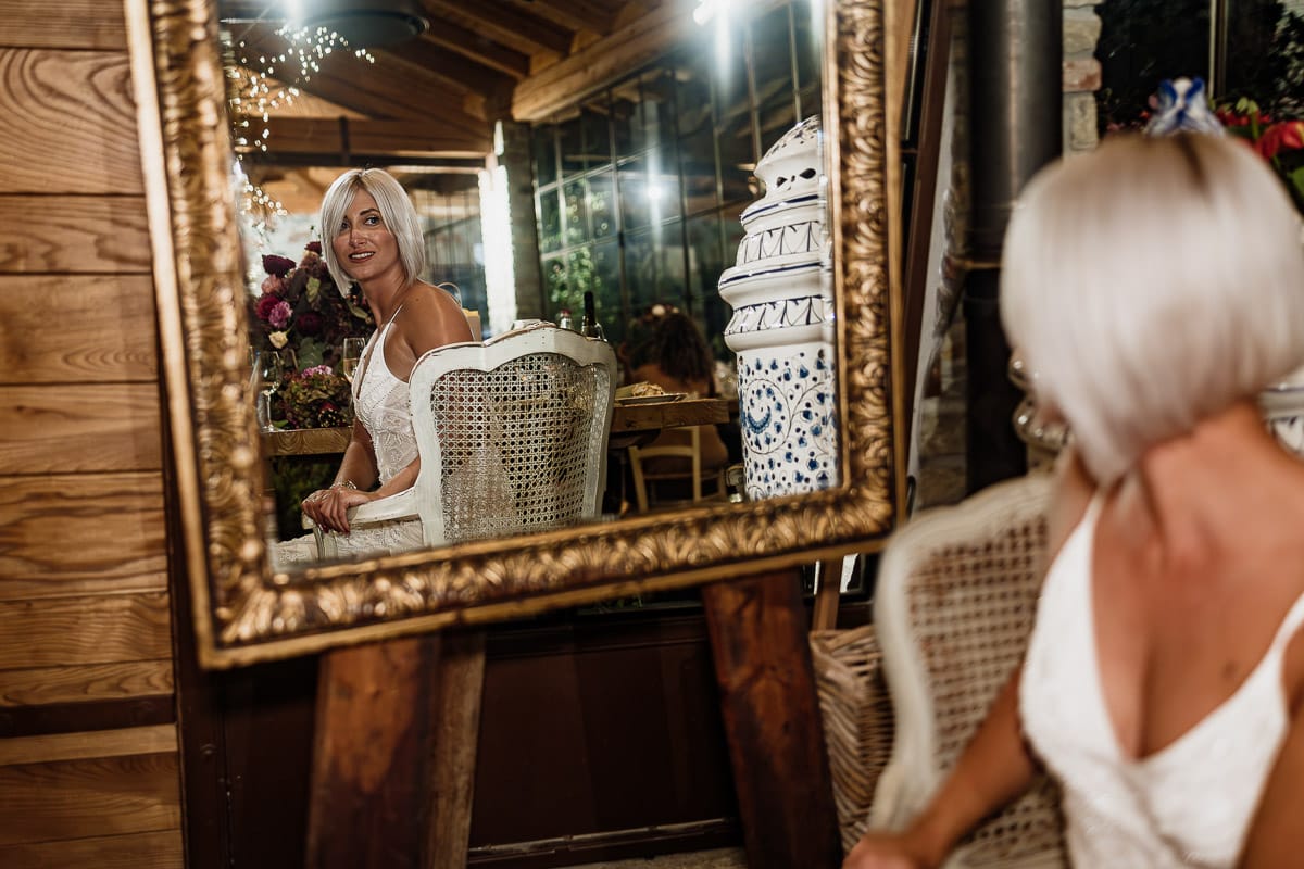 Matrimonio boho-chic da favola nel Monferrato. Fotografo matrimonio Monferrato. Matrimonio a Molare. Agriturismo "A Modo Mio" Ricevimento. Sposa riflessa nelllo specchio.
