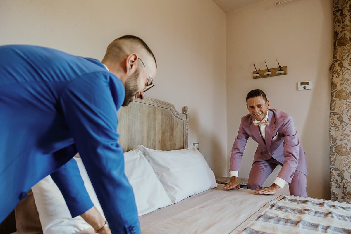 Matrimonio boho-chic da favola nel Monferrato. Matrimonio a Molare. Agriturismo "A Modo Mio". Preparazione dello sposo. sposo sistema il letto con il testimone.