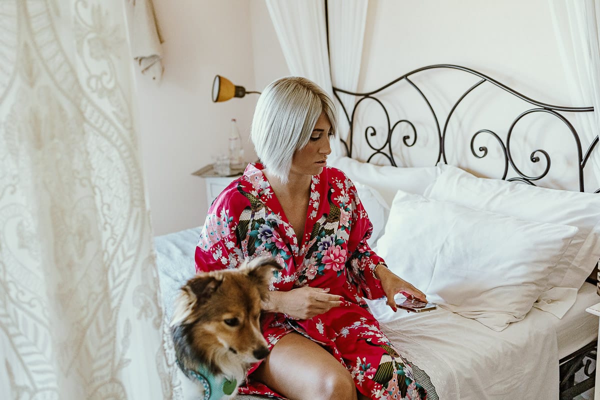 Matrimonio boho-chic da favola nel Monferrato. Matrimonio a Molare. Agriturismo "A Modo Mio". Preparazione della sposa. sposa sul letto con il volpino