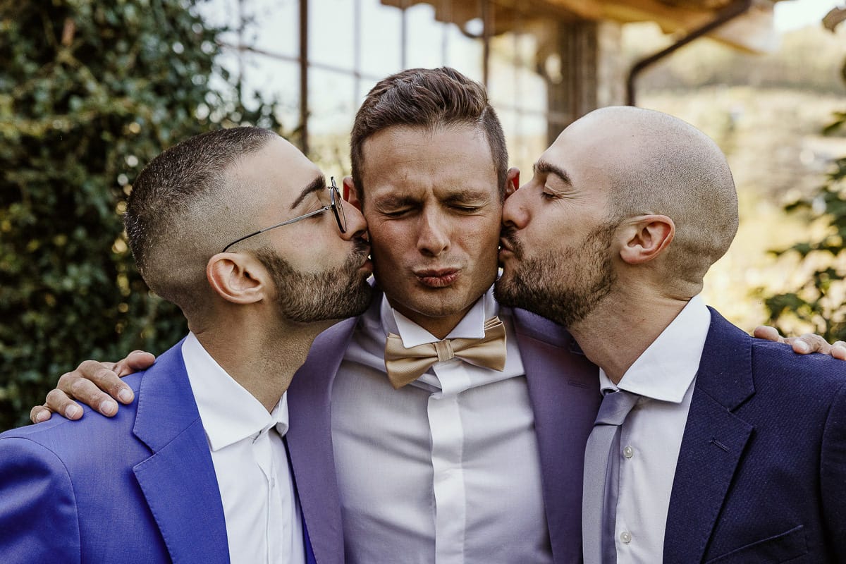 Matrimonio boho-chic da favola nel Monferrato. Matrimonio a Molare. Agriturismo "A Modo Mio". Preparazione dello sposo. Ritratto dello sposo in giardino. I testimoni lo baciano.