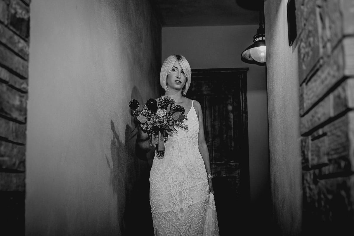 Matrimonio boho-chic da favola nel Monferrato. Matrimonio a Molare. Agriturismo "A Modo Mio". Preparazione della sposa. Sposa esce dalla stanza. Bianco e nero.