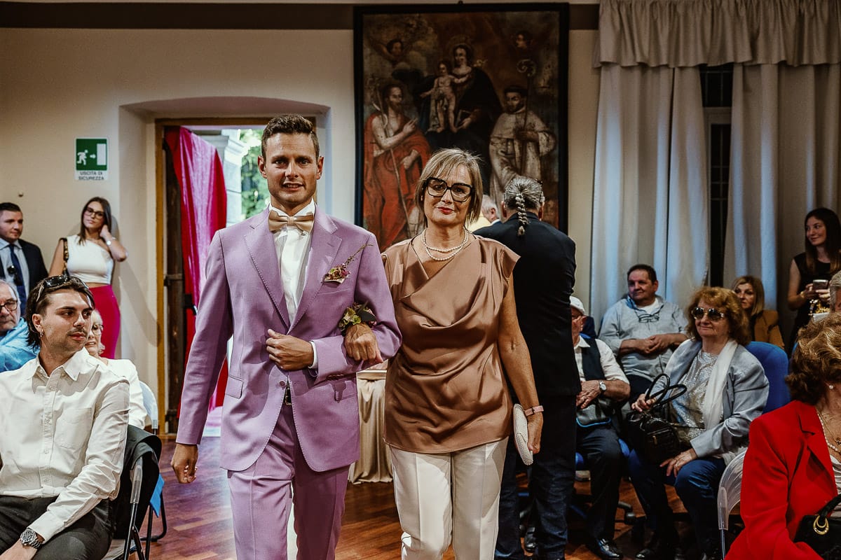 Matrimonio boho-chic da favola nel Monferrato. Fotografo matrimonio Monferrato. matrimonio a Molare (AL). cerimonia civile nel comune di Molare. Entrata dello sposo con la mamma.