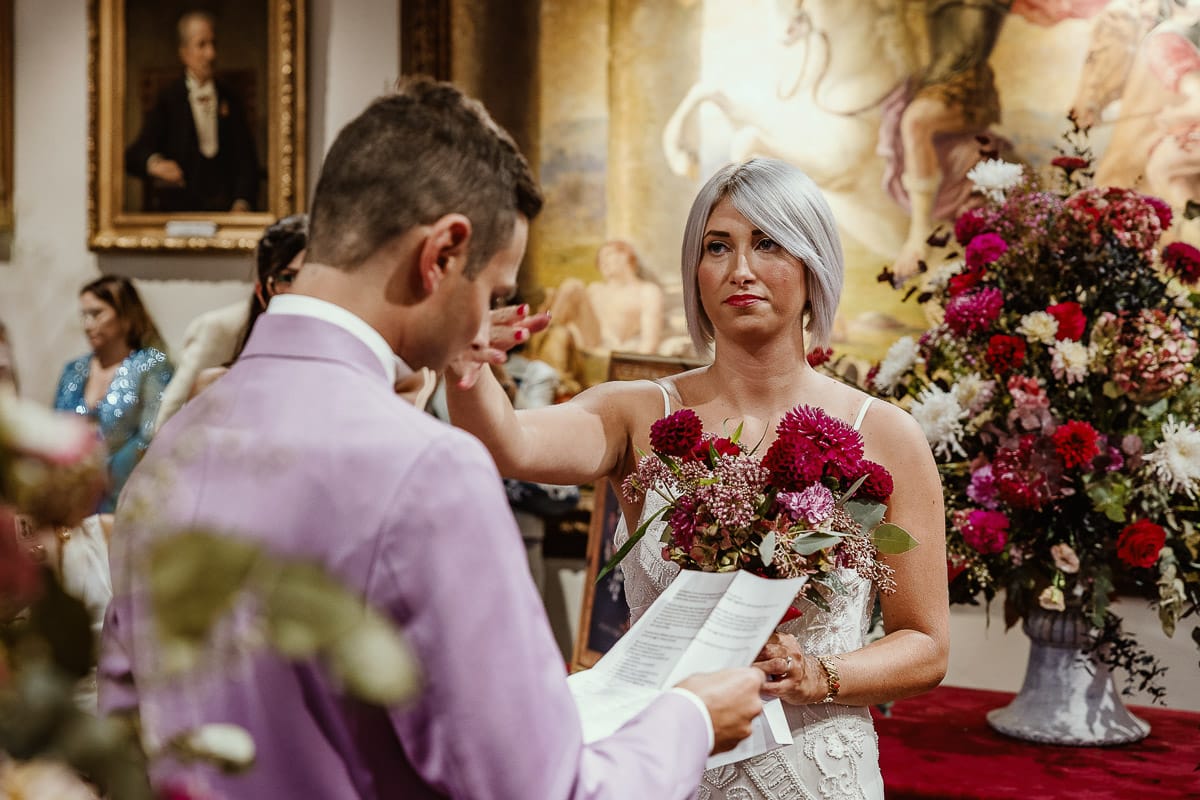 Matrimonio boho-chic da favola nel Monferrato. Fotografo matrimonio Monferrato. matrimonio a Molare (AL). cerimonia civile nel comune di Molare. Sposo legge le promesse commosso. Sposa lo accarezza.