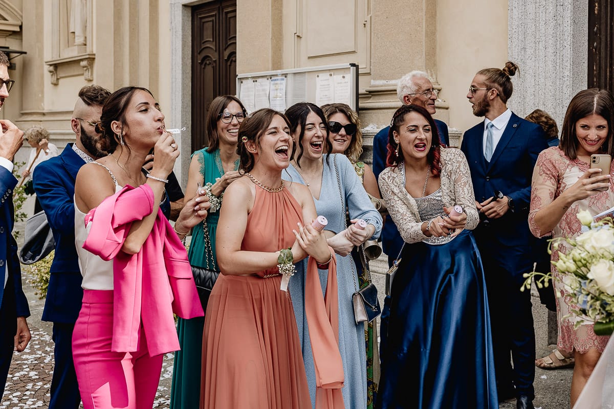 Fotografo matrimonio Torino | Tenuta La Michelina | Pinerolo. Cerimonia religiosa nella chiesa di Santa Maria Maggiore di Poirino. Amici degli sposi sparano i coriandoli.