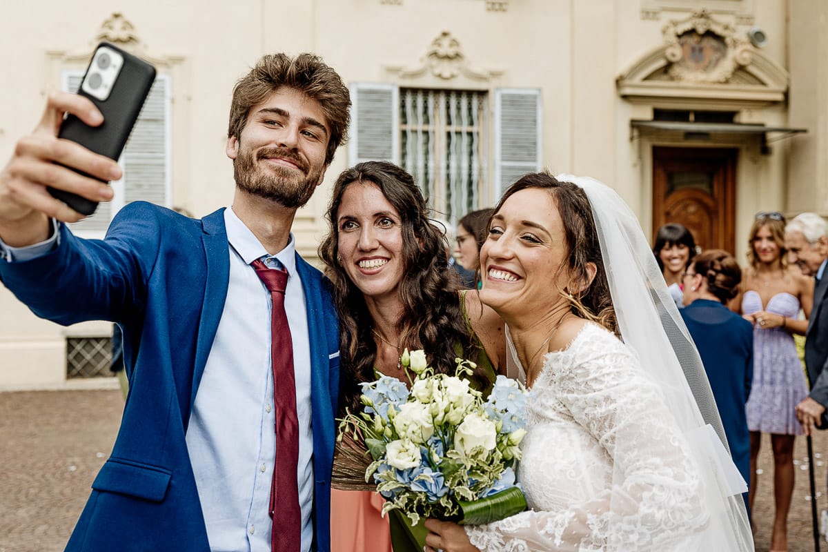 Fotografo matrimonio Torino | Tenuta La Michelina | Pinerolo. Cerimonia religiosa nella chiesa di Santa Maria Maggiore di Poirino. Selfie della sposa con la testimone e un amico.