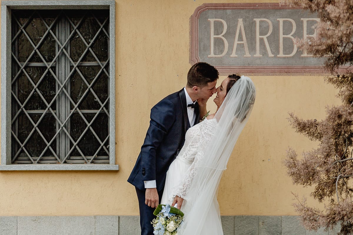 Fotografo matrimonio Torino | Tenuta La Michelina | Pinerolo. Ritratto di coppia degli sposi. Sposi davanti al negozio di Barberia