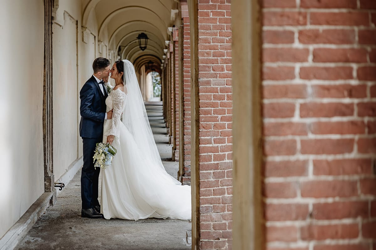 Fotografo matrimonio Torino | Tenuta La Michelina | Pinerolo. Ritratto di coppia degli sposi. Sposi sotto un portico medievale. Sposi si baciano
