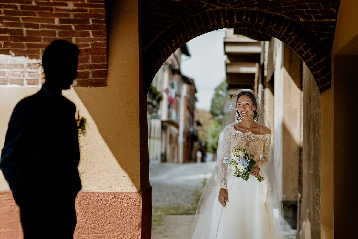 Fotografo matrimonio Torino | Tenuta La Michelina | Pinerolo. Ritratto di coppia degli sposi. Sposi sotto nel centro storico di Poirino. Sposa illuminata e sposo in ombra, in silhouette.