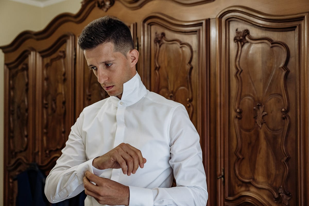 Fotografo matrimonio Torino | Tenuta La Michelina | Pinerolo. Preparazione dello sposo. Sposo si abbottona la camicia