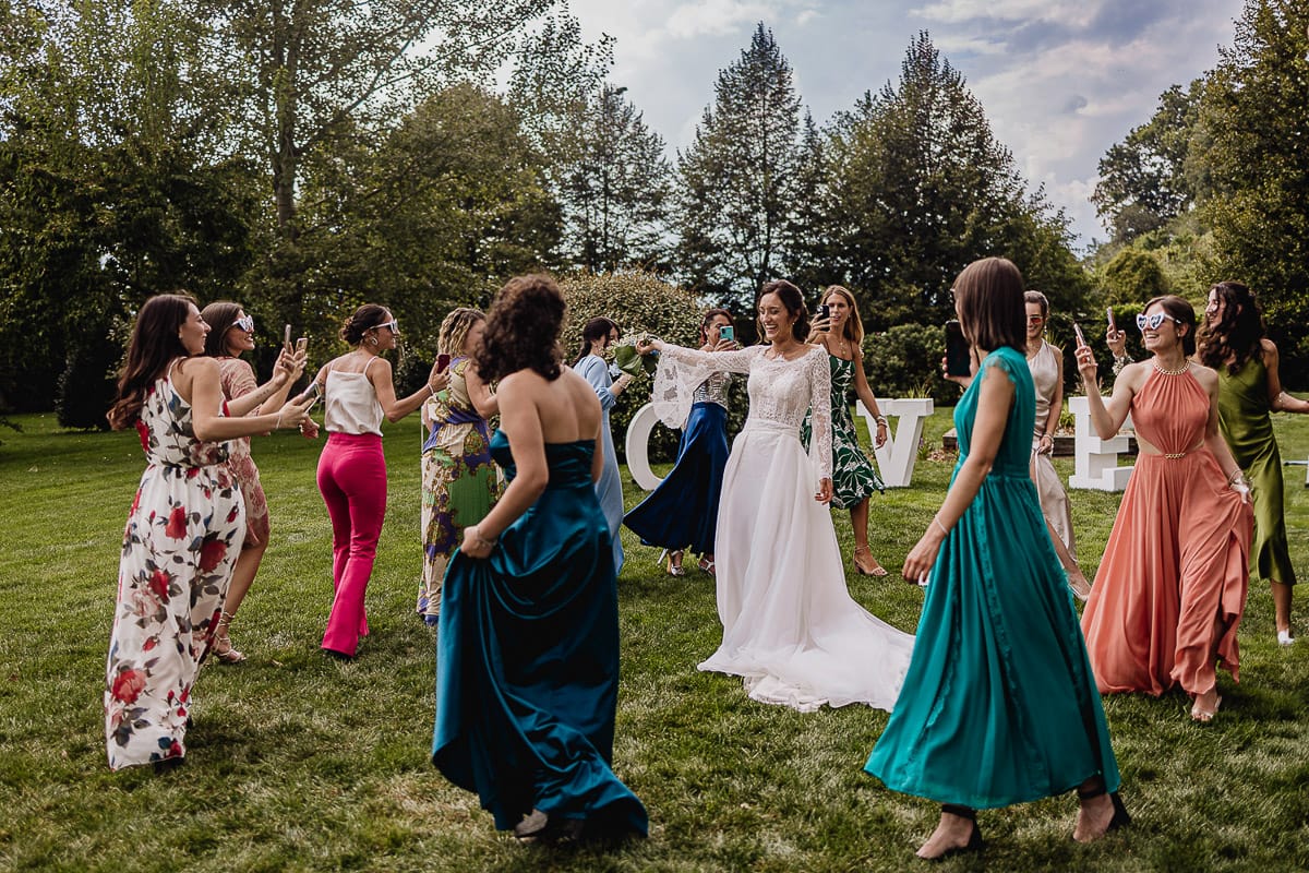 Fotografo matrimonio Torino | Tenuta La Michelina | Pinerolo. Aperitivo. le amiche girano in tondo con la sposa nel mezzo.