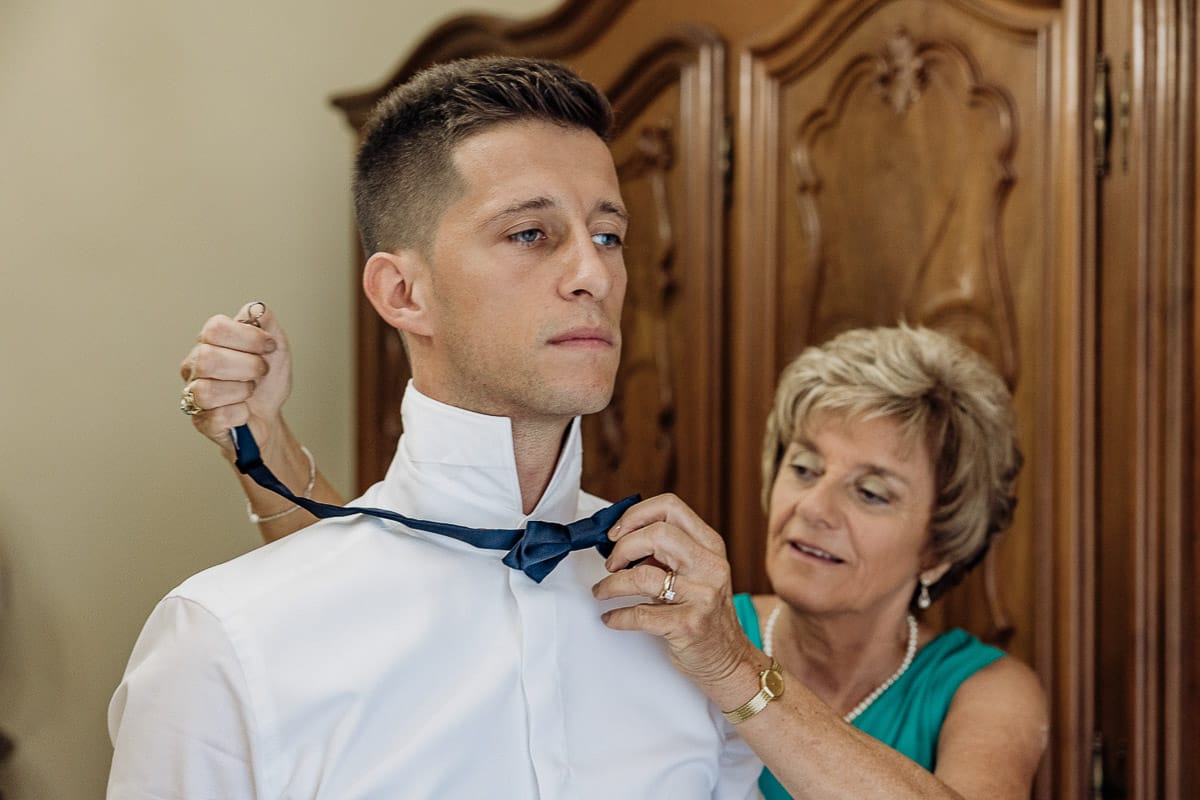 Fotografo matrimonio Torino | Tenuta La Michelina | Pinerolo. Preparazione dello sposo. Mamma mette il papillon allo sposo