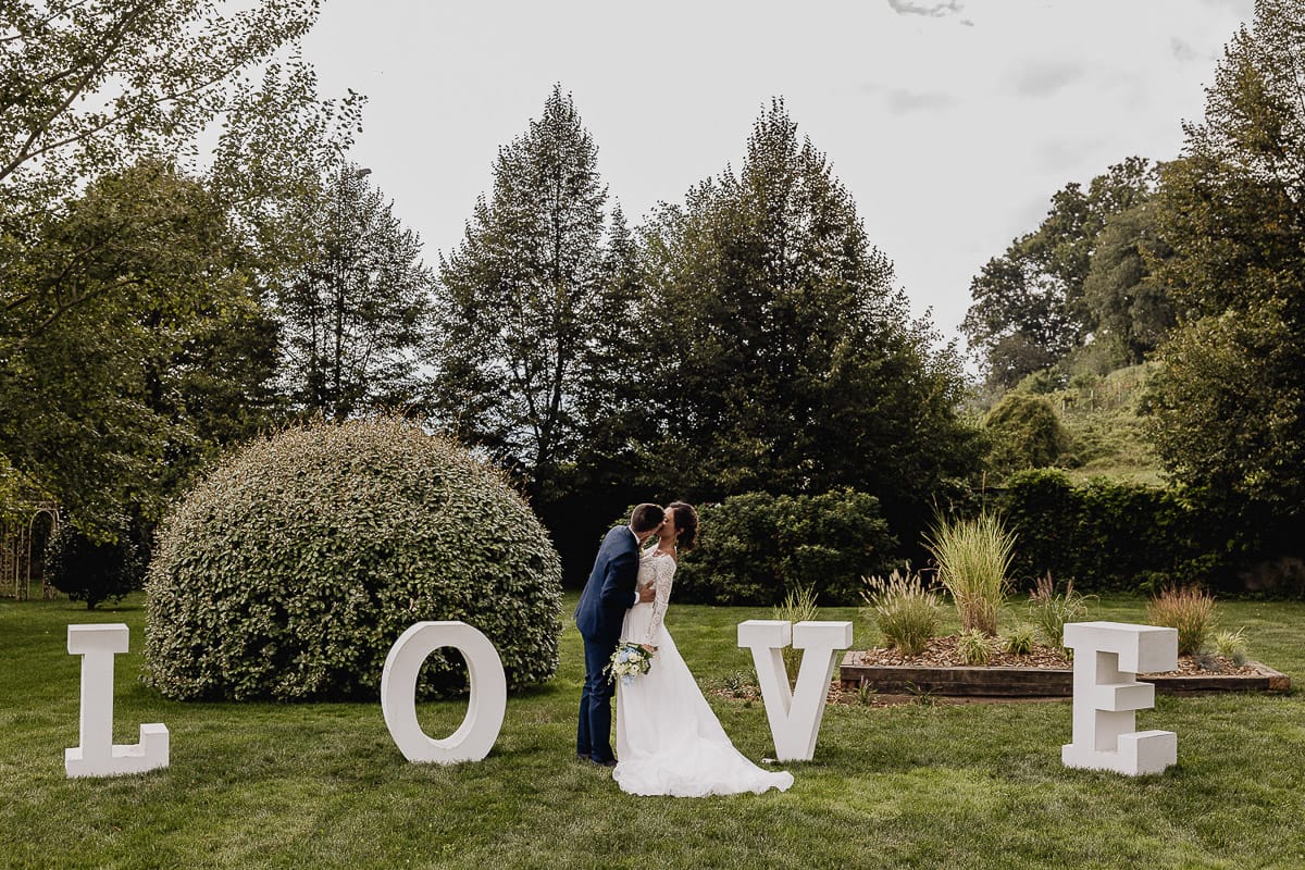Fotografo matrimonio Torino | Tenuta La Michelina | Pinerolo. Sessione di coppia degli sposi.Sposi si baciano davanti alla scritta LOVE