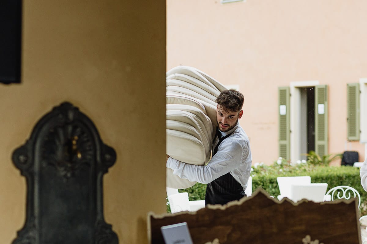 Fotografo matrimonio Torino | Tenuta La Michelina | Pinerolo. temporale improvviso. Il personale porta i cuscini al riparo.