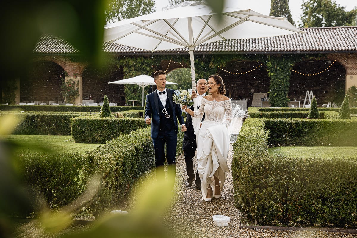 Fotografo matrimonio Torino | Tenuta La Michelina | Pinerolo. Temporale improvviso. Sposi devono entrare in sala sotto un ombrellone