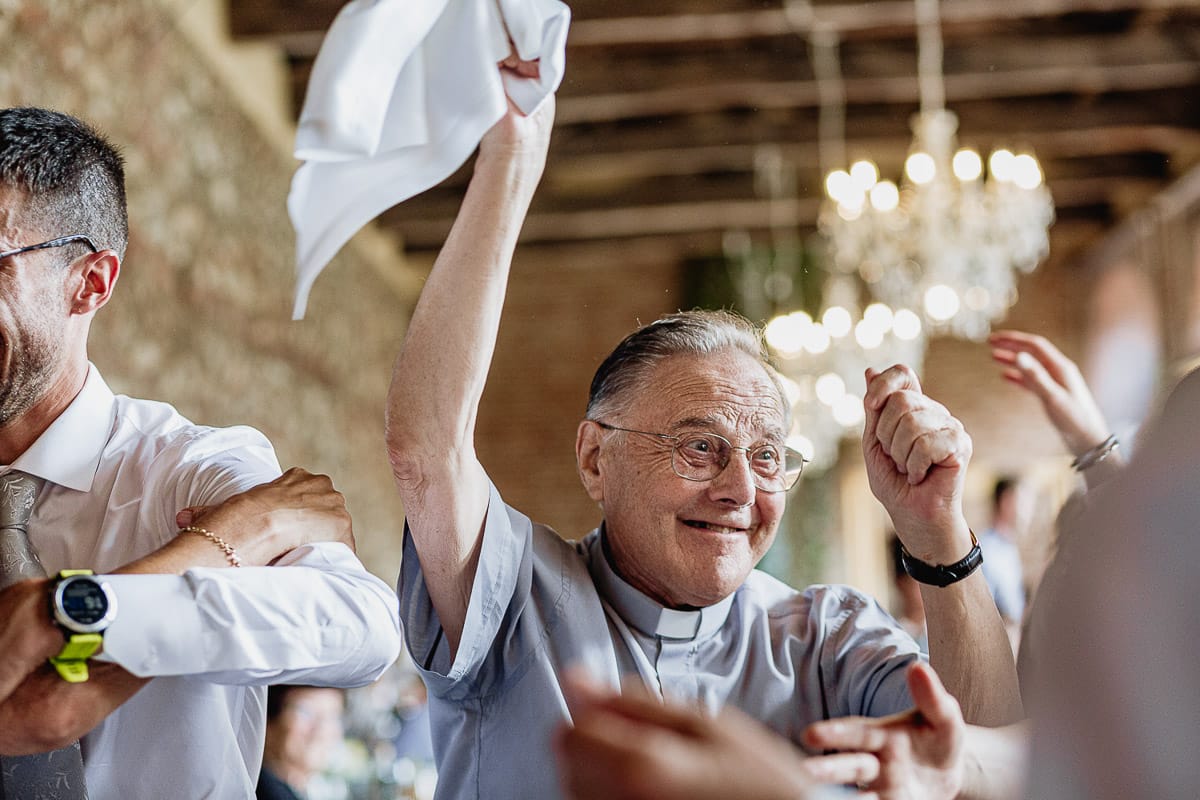 Fotografo matrimonio Torino | Tenuta La Michelina | Pinerolo. Ricevimento. Sacerdote balla sventolando il tovagliolo.
