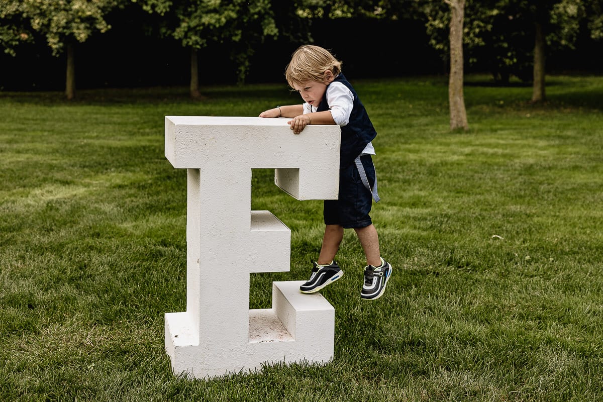 Fotografo matrimonio Torino | Tenuta La Michelina | Pinerolo. Ricevimento. Bambino si arrmpica sulla lettera E