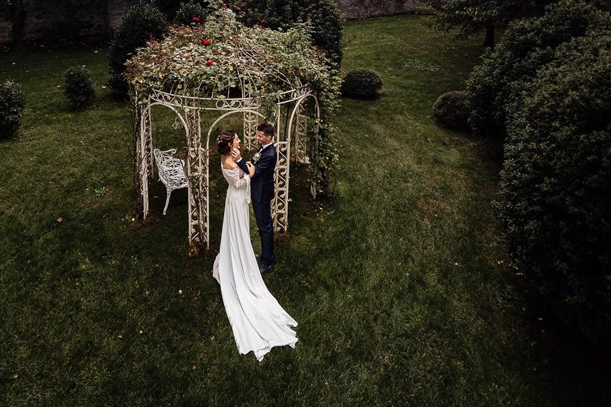 Fotografo matrimonio Torino | Tenuta La Michelina | Pinerolo. Ricevimento. Sessione fotografica di coppia degli sposi in giardino. Foto aerea dal drone. Sposi vicino ad un gazebo di ferro con le rose rampicanti.