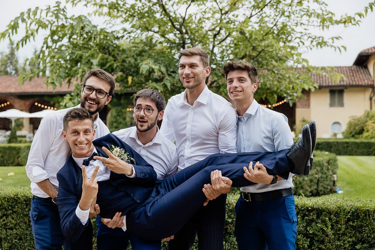 Fotografo matrimonio Torino | Tenuta La Michelina | Pinerolo. Ricevimento. Giochi e scherzi. Gli amici prendono in braccio lo sposo.