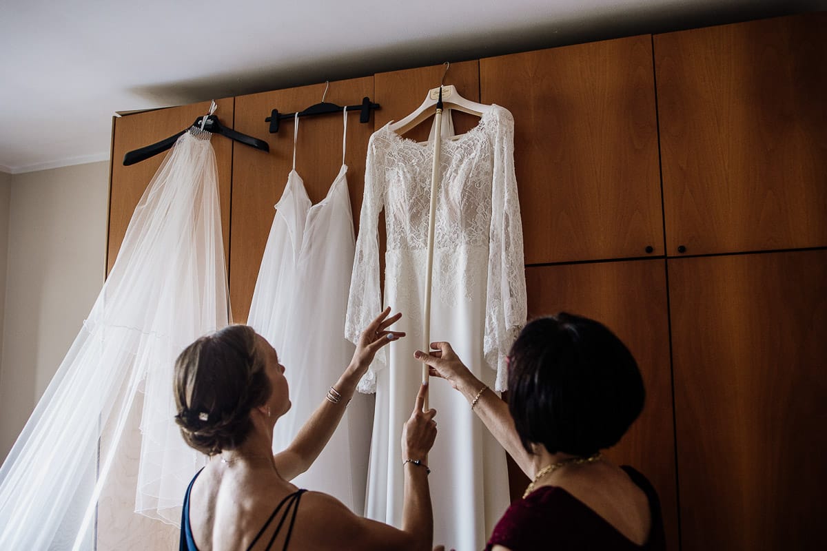 Fotografo matrimonio Torino | Tenuta La Michelina | Pinerolo. Preparazione della sposa. Madre e sorella prendono l'abito della sposa