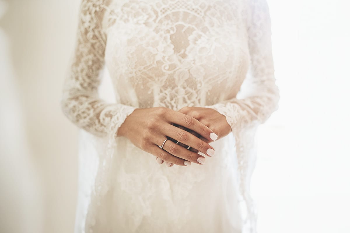 Fotografo matrimonio Torino | Tenuta La Michelina | Pinerolo. Preparazione della sposa. Dettaglio delle mani della sposa e dell'abito di pizzo