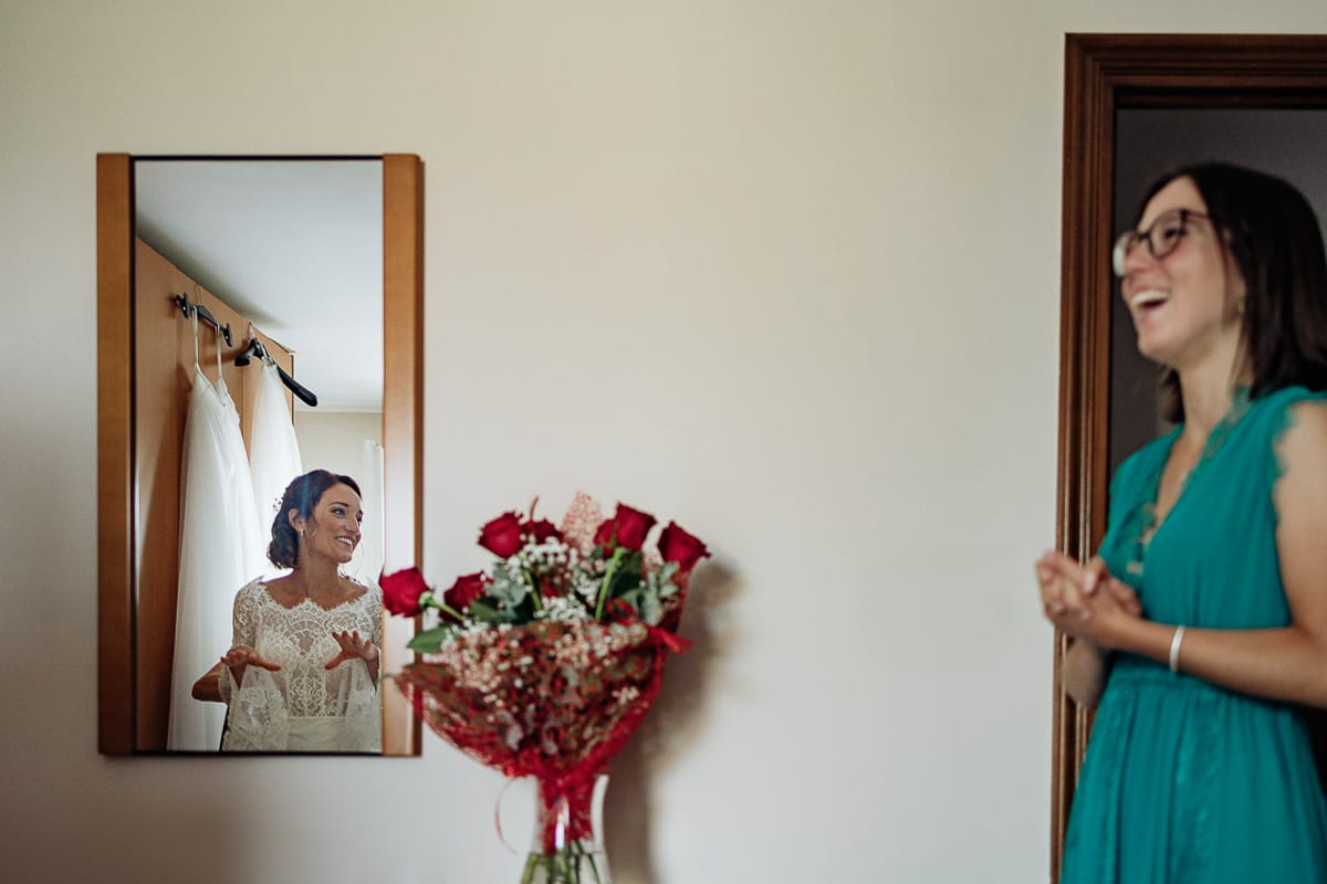Fotografo matrimonio Torino | Tenuta La Michelina | Pinerolo. Preparazione della sposa. Vestizione della sposa riflessa allo specchio Arrivo di una testimone