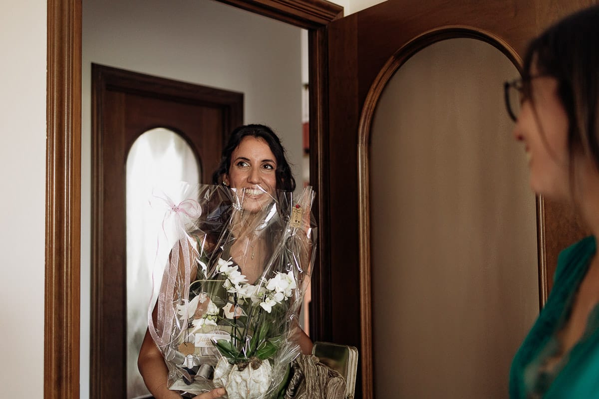 Fotografo matrimonio Torino | Tenuta La Michelina | Pinerolo. Preparazione della sposa. Vestizione della sposa . Arrivo della seconda testimone con un vaso di fiori.