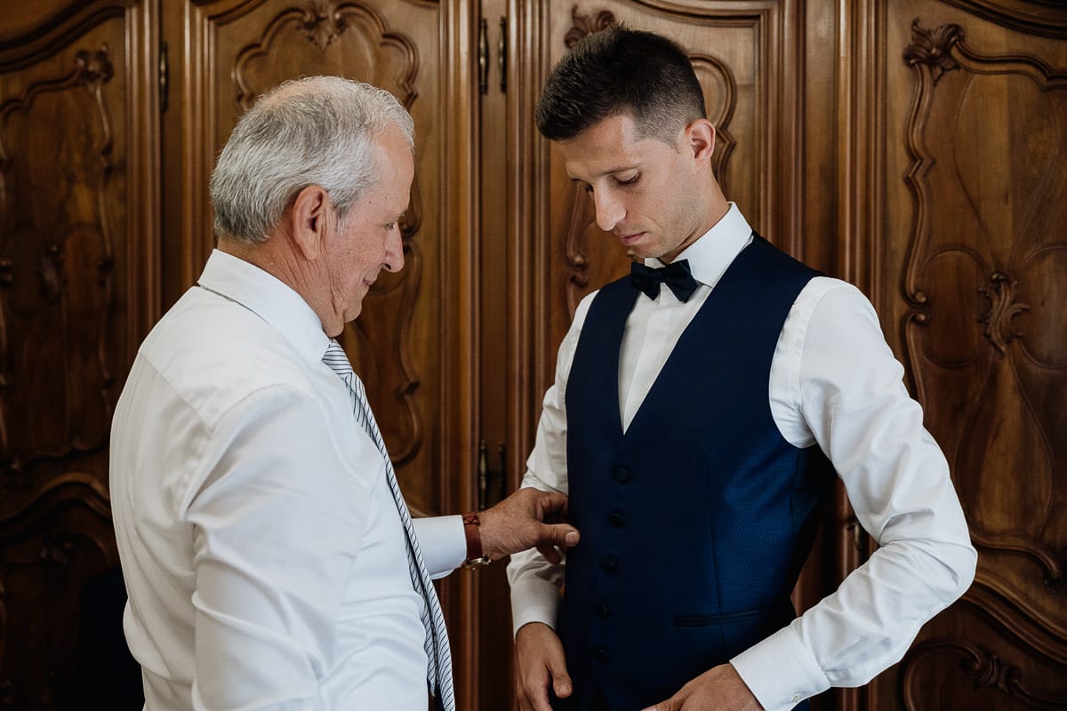 Fotografo matrimonio Torino | Tenuta La Michelina | Pinerolo. Preparazione dello sposo. Padre abbottona il gilet dello sposo