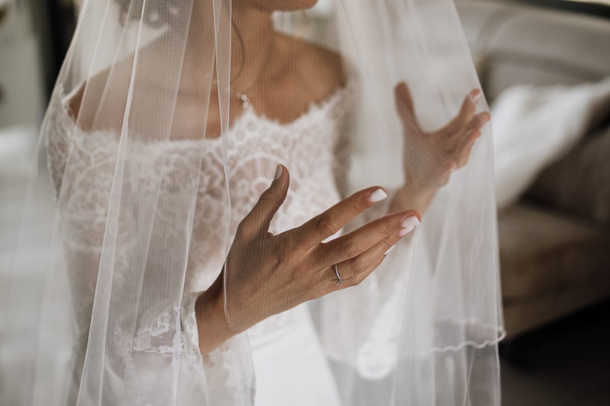 Fotografo matrimonio Torino | Tenuta La Michelina | Pinerolo. Preparazione della sposa. Sposa con il velo calato. Dettaglio sulla mano