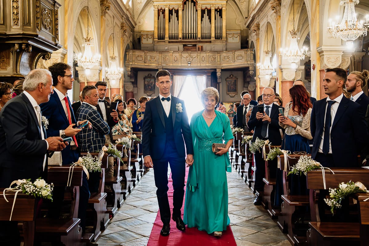 Fotografo matrimonio Torino | Tenuta La Michelina | Pinerolo. Cerimonia religiosa nella chiesa di Santa Maria Maggiore di Poirino. Entrata dello sposo con la mamma.