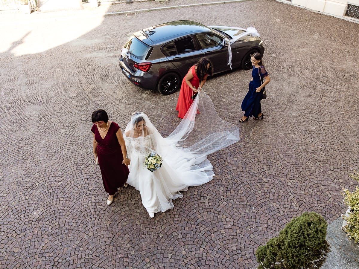 Fotografo matrimonio Torino | Tenuta La Michelina | Pinerolo. Cerimonia religiosa nella chiesa di Santa Maria Maggiore di Poirino. Ritratto della sposa che si dirige verso la chiesa. Ripresa aerea dal drone.
