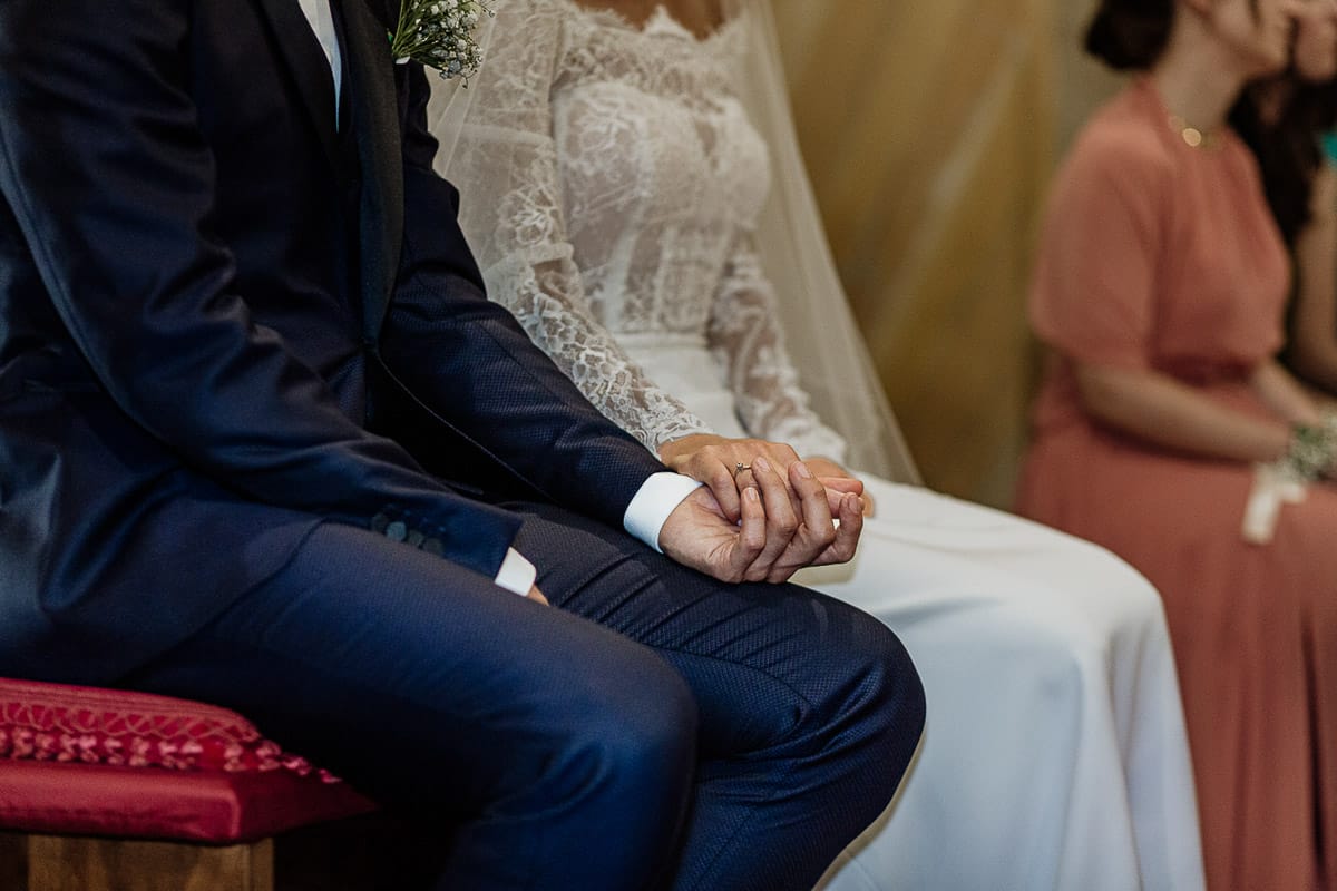 Fotografo matrimonio Torino | Tenuta La Michelina | Pinerolo. Cerimonia religiosa nella chiesa di Santa Maria Maggiore di Poirino. Sposi si danno la mano, dettaglio.