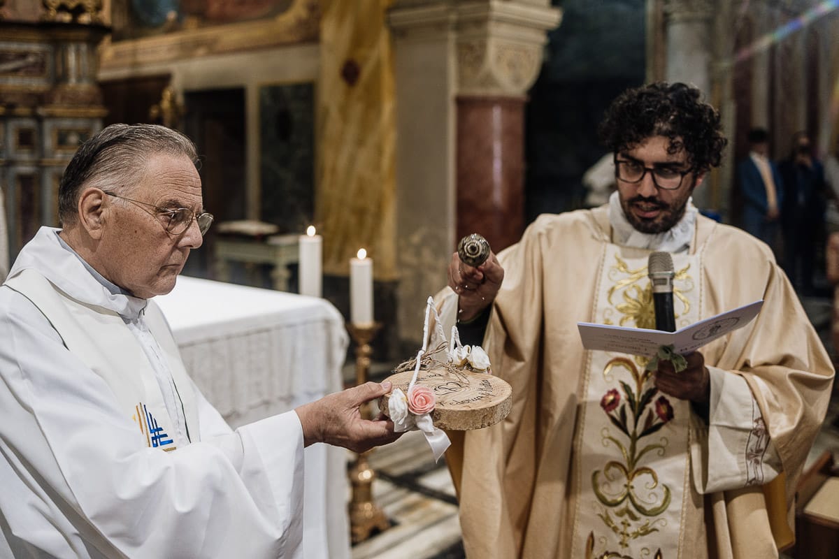 Fotografo matrimonio Torino | Tenuta La Michelina | Pinerolo. Cerimonia religiosa nella chiesa di Santa Maria Maggiore di Poirino. sacerdote benedice gli anelli.