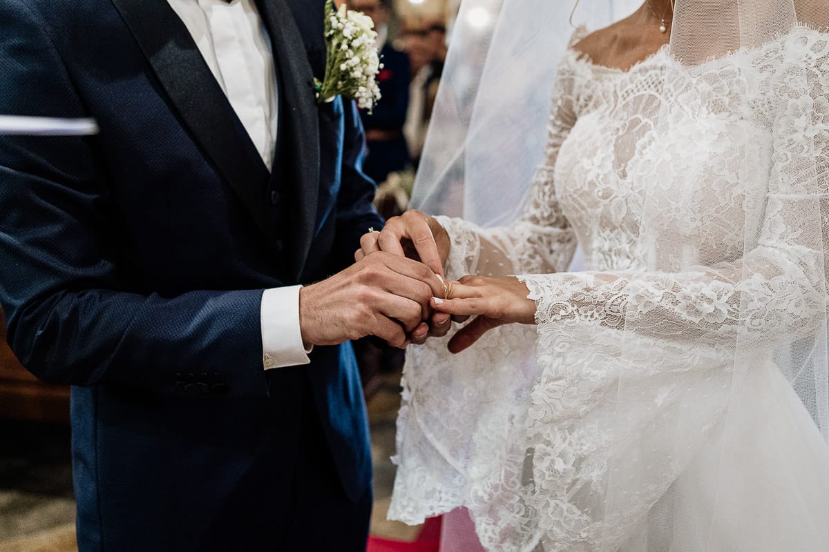 Fotografo matrimonio Torino | Tenuta La Michelina | Pinerolo. Cerimonia religiosa nella chiesa di Santa Maria Maggiore di Poirino. Sposo mette l'anello al dito della sposa