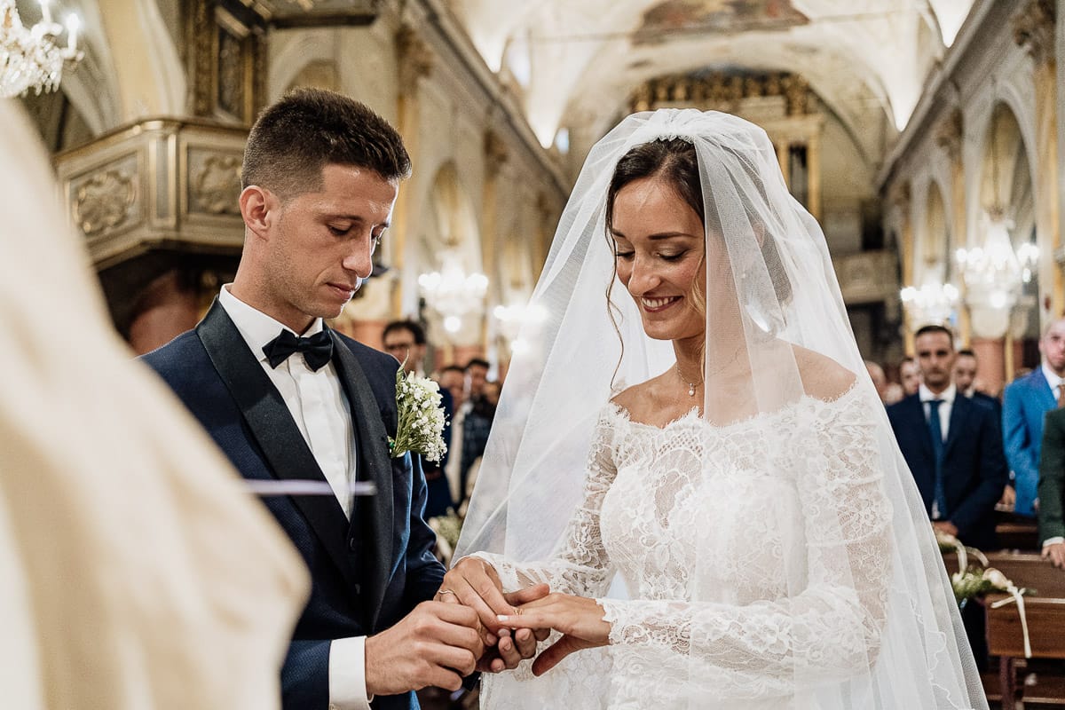 Fotografo matrimonio Torino | Tenuta La Michelina | Pinerolo. Cerimonia religiosa nella chiesa di Santa Maria Maggiore di Poirino. Sposo mette l'anello alla sposa