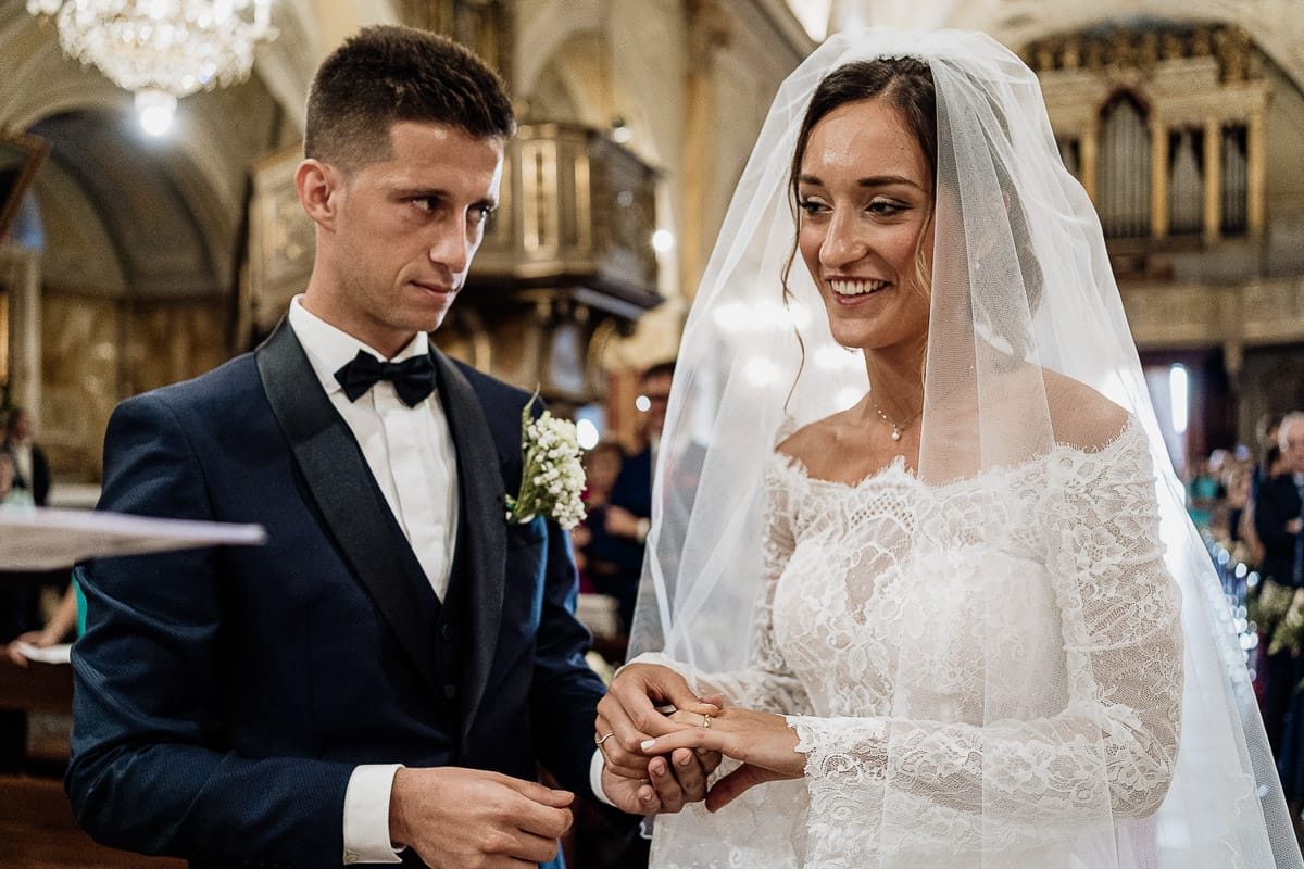 Fotografo matrimonio Torino | Tenuta La Michelina | Pinerolo. Cerimonia religiosa nella chiesa di Santa Maria Maggiore di Poirino. Sposa si infila bene l'anello.