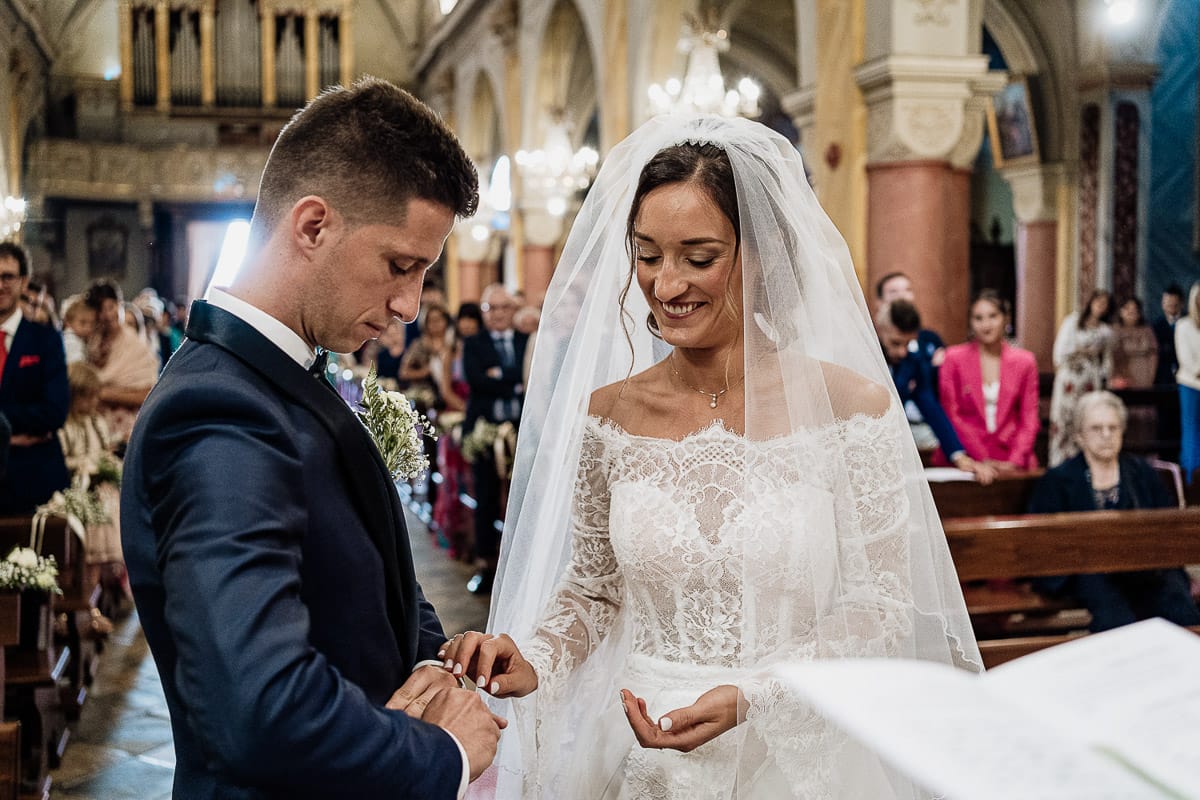 Fotografo matrimonio Torino | Tenuta La Michelina | Pinerolo. Cerimonia religiosa nella chiesa di Santa Maria Maggiore di Poirino. Sposo si infila meglio l'anello che fa fatica ad entrare.