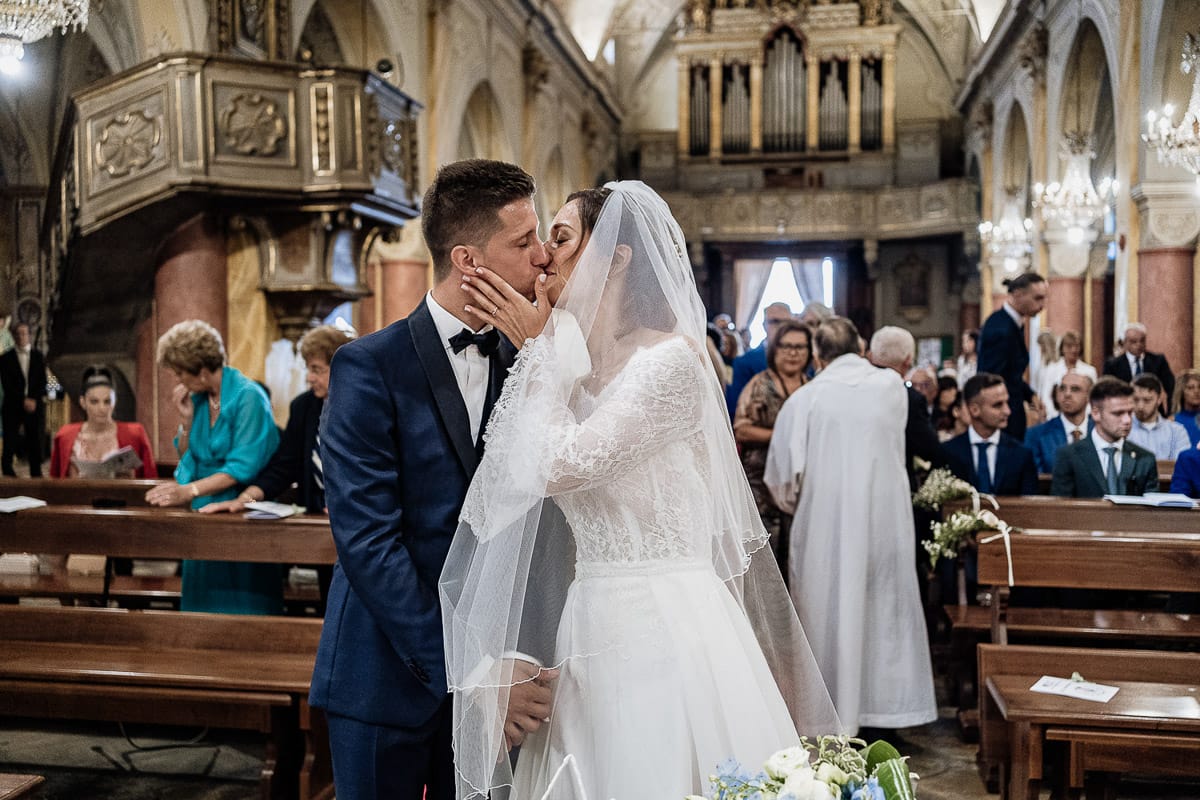 Fotografo matrimonio Torino | Tenuta La Michelina | Pinerolo. Cerimonia religiosa nella chiesa di Santa Maria Maggiore di Poirino. Gli sposi si baciano