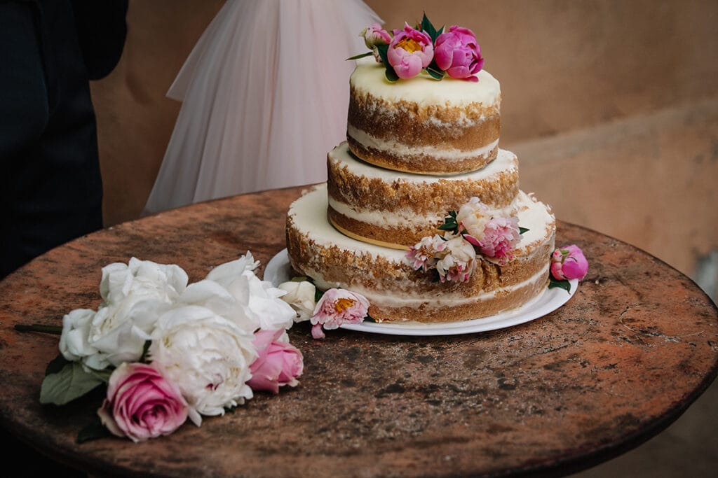 Tendenze matrimoni 2025. Matrimonio boho-chic ecofriendly. Naked cake e fiori di stagione, peonie e rose