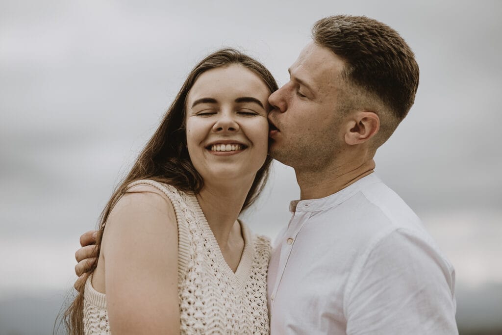 Proposta di matrimonio a Torino di Svajunaas ad Erika al Monte dei Cappuccini. Erika sorride, Svajunaas la bacia sulla guancia
