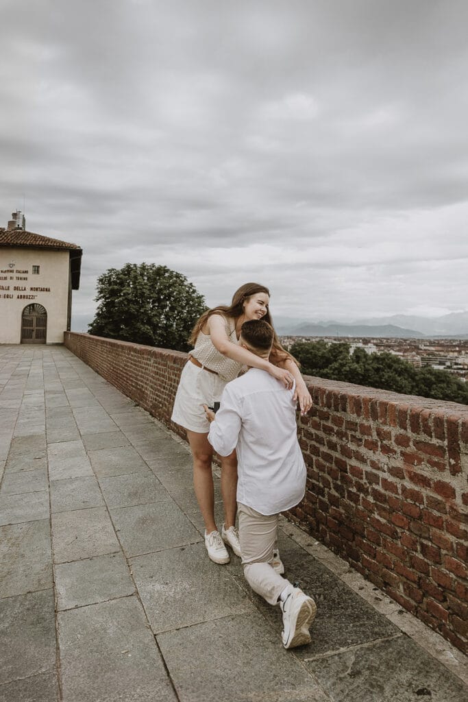 Proposta di matrimonio a Torino di Svajunaas ad Erika al Monte dei Cappuccini. Svajunaas si inginocchia davanti ad Erika. Erika lo abbraccia