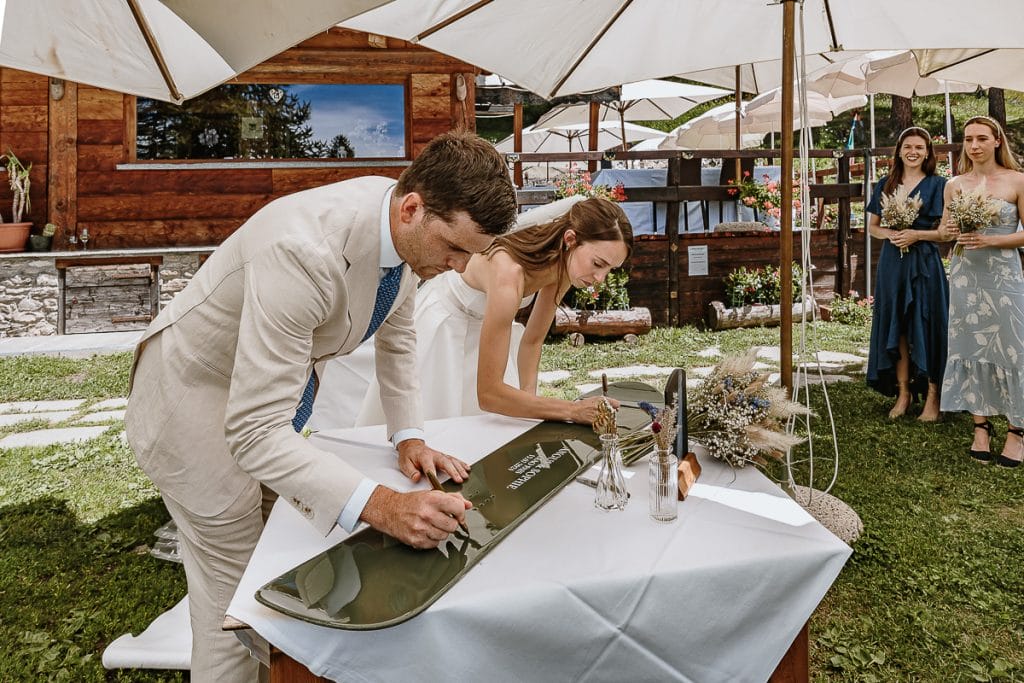 Destination wedding in Piemonte, elopement di Sophie e Angus a Sauze d'Oulx, Hotel Ciao Pais. Gli sposi firmano la tavola da snowboard