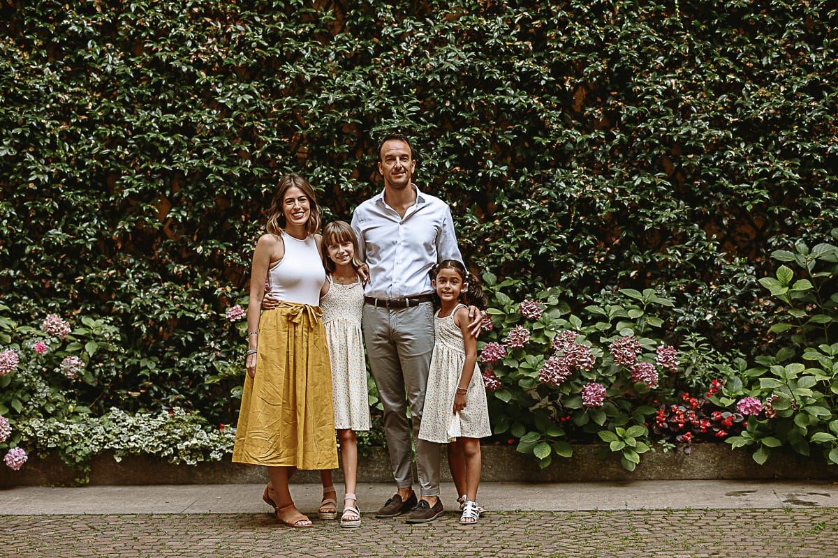 Fotografia di famiglia in vacanza a Torino: famiglia americane in un cortile di un palazzo del centro davanti ad una parete ricoperta di edera.