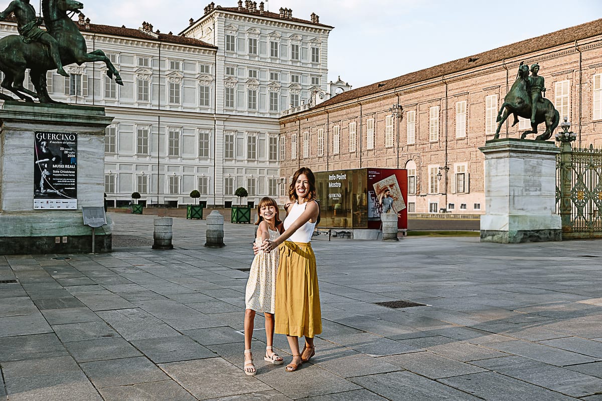 Fotografia di famiglia in vacanza a Torino: mamma con la figlia più grande Emma ballano davanti a Palazzo Reale