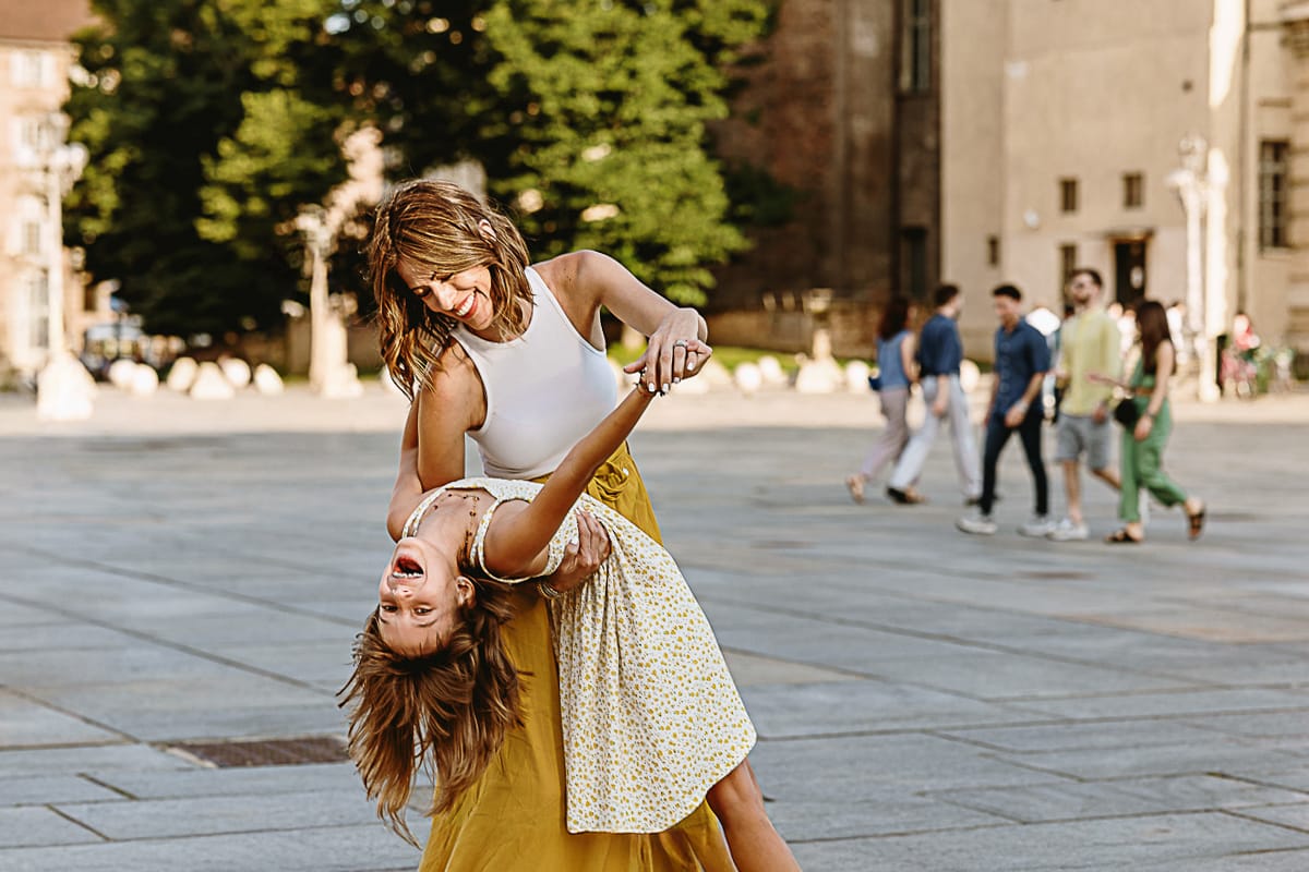 Fotografia di famiglia in vacanza a Torino: mamma con la figlia più grande Emma ballano davanti a Palazzo Reale