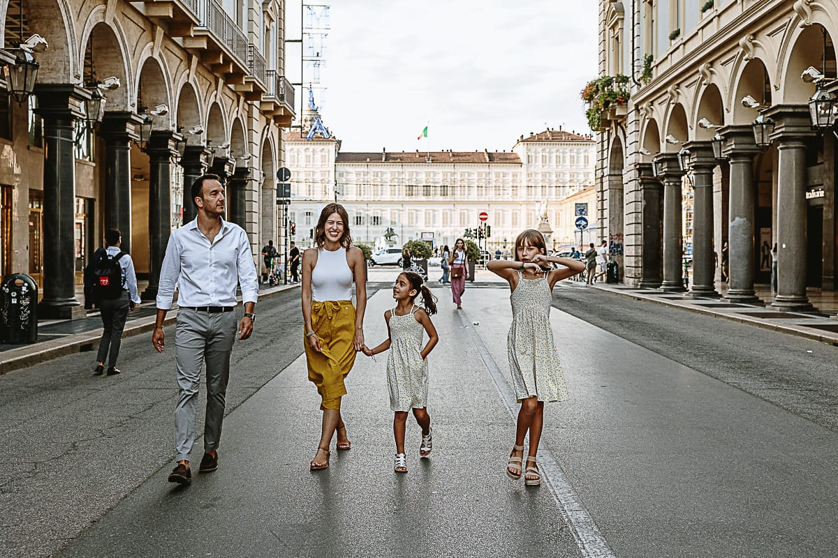 Fotografia di famiglia in vacanza a Torino: famiglia cammina in via Roma