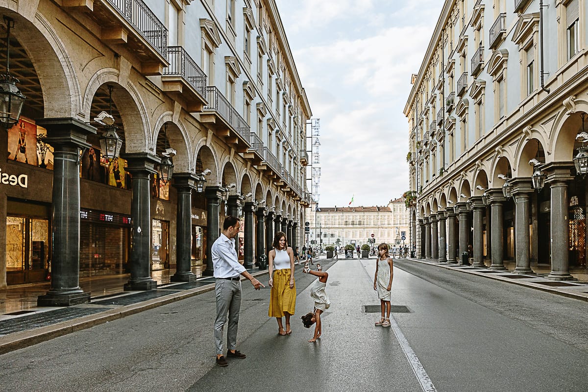 Fotografia di famiglia in vacanza a Torino: famiglia cammina in via Roma