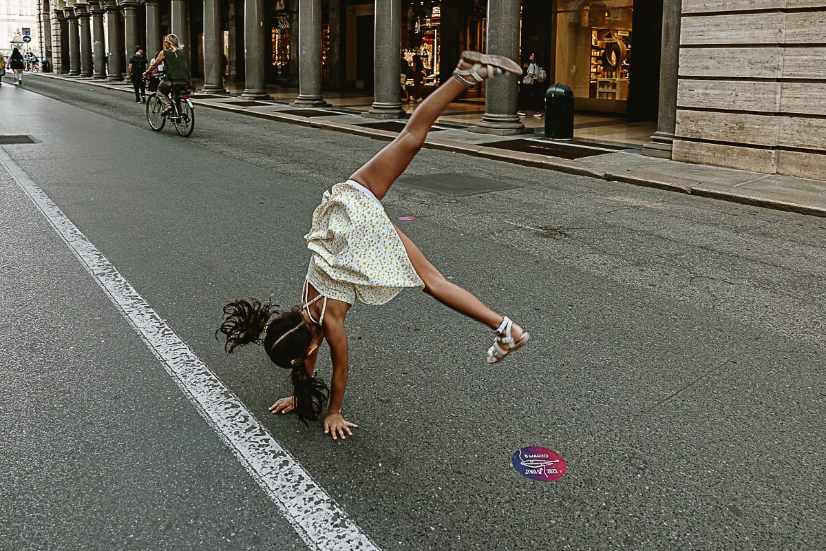 Fotografia di famiglia in vacanza a Torino: bambina fa la ruota in via Roma.