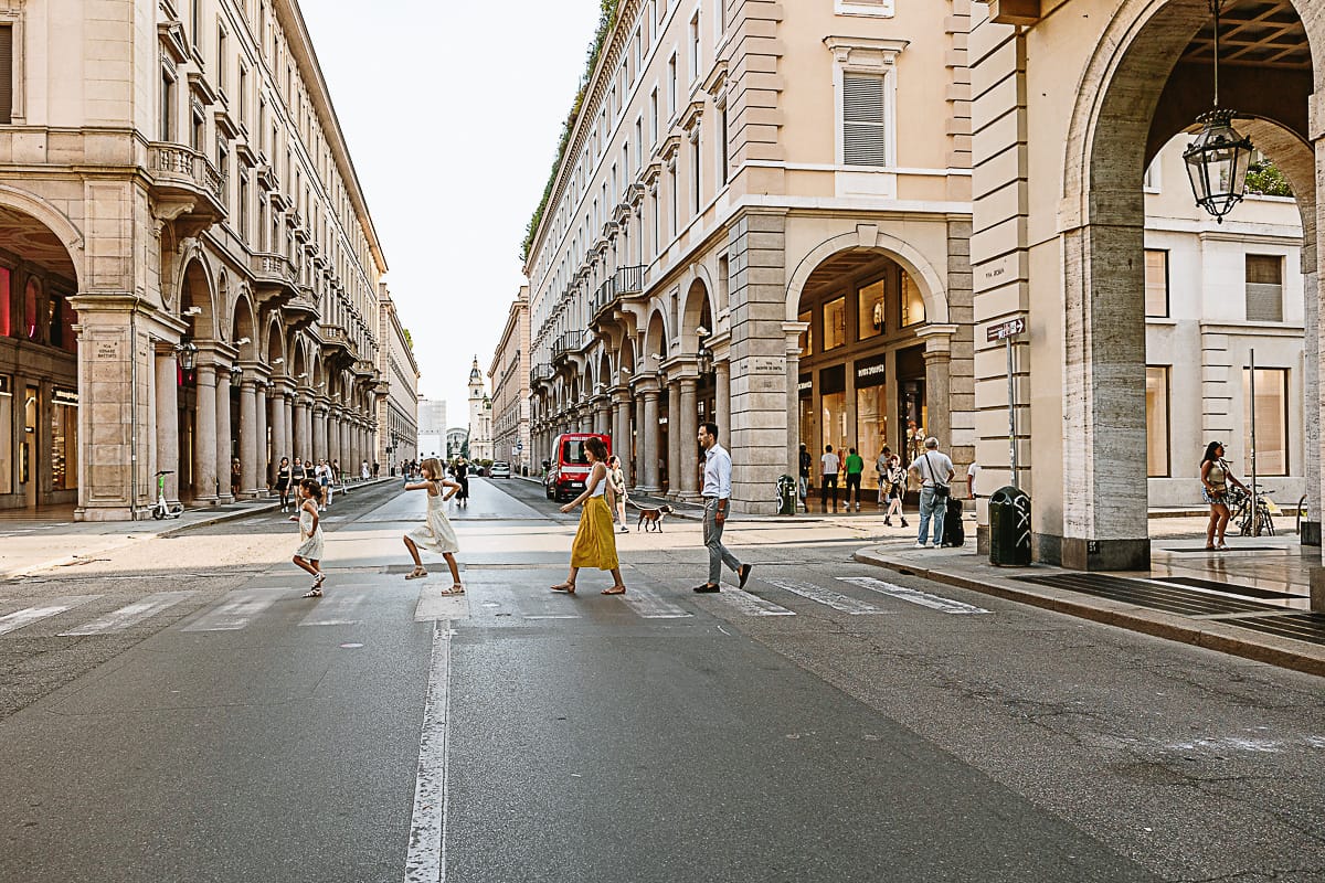 Fotografia di famiglia in vacanza a Torino: famiglia attraversa via Roma.