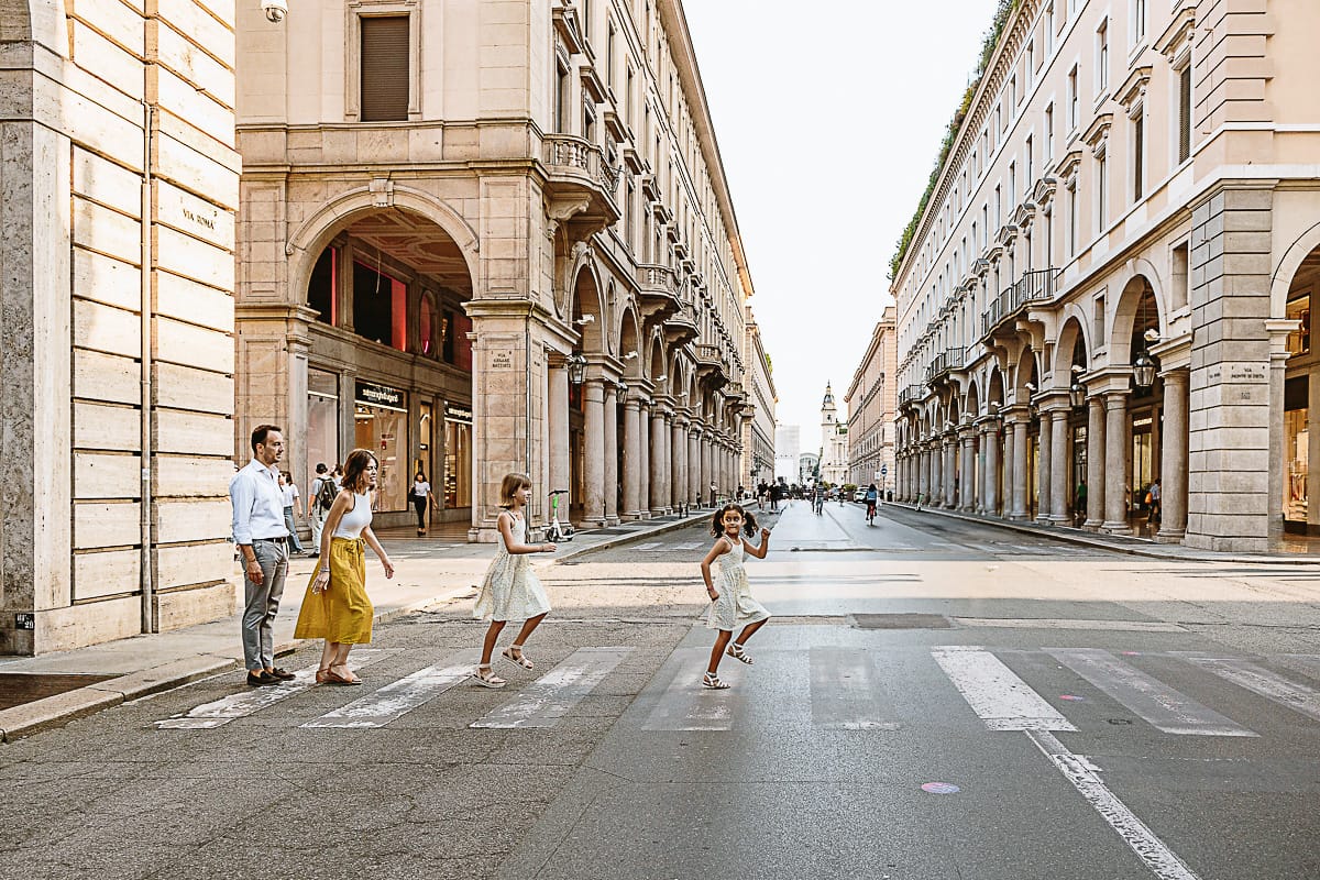 Fotografia di famiglia in vacanza a Torino: famiglia attraversa via Roma.